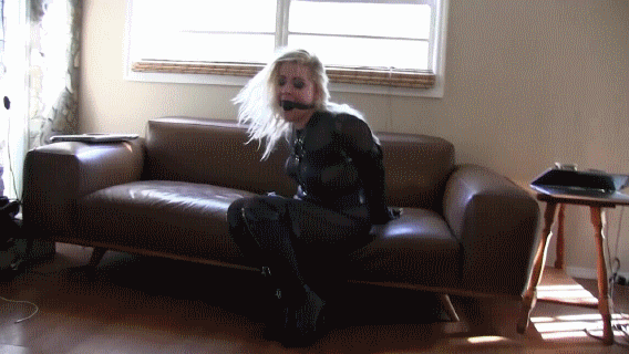 Sexy blond in a catsuit and leather bondage puts on a struggling show